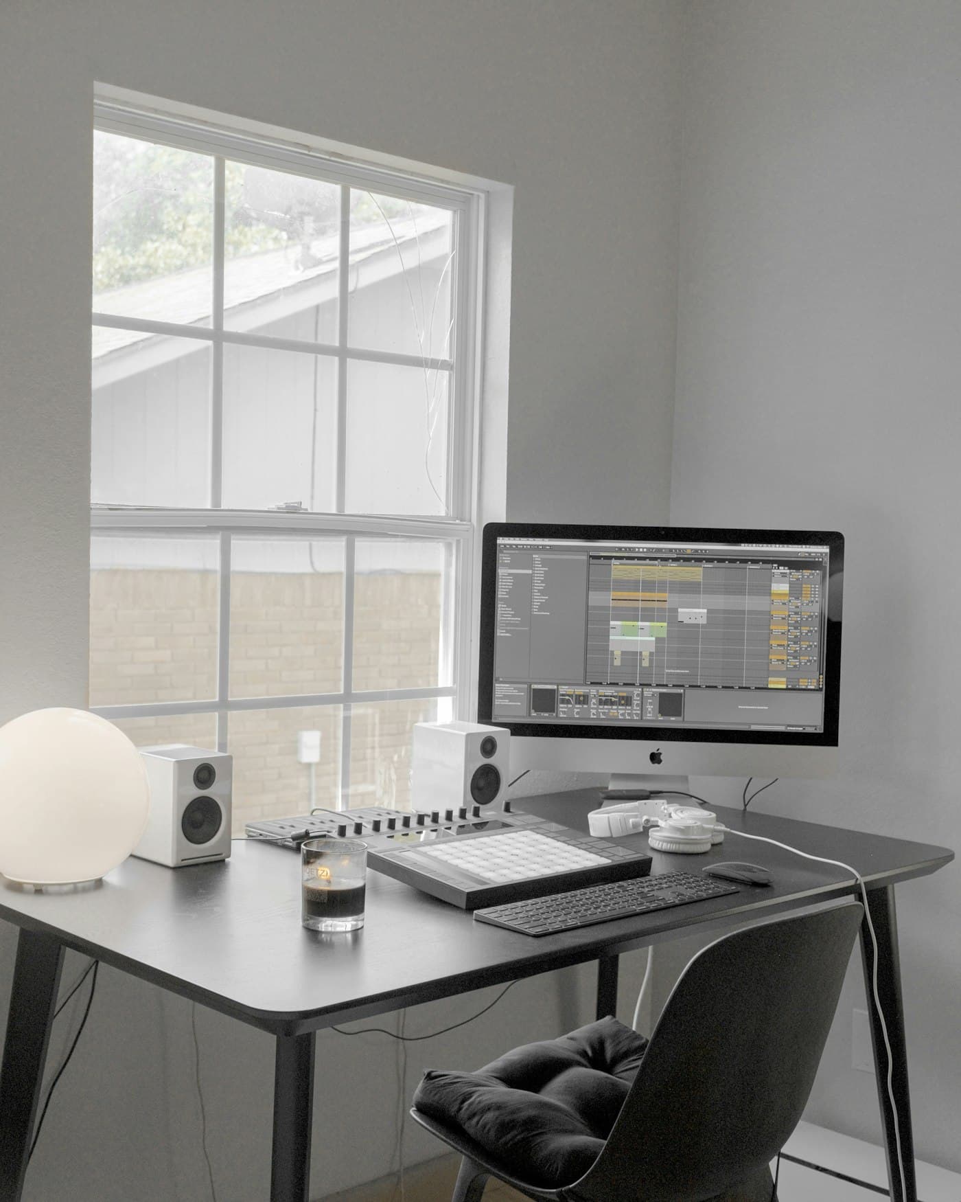 A bright desk beside a window with a monitor showing a working session