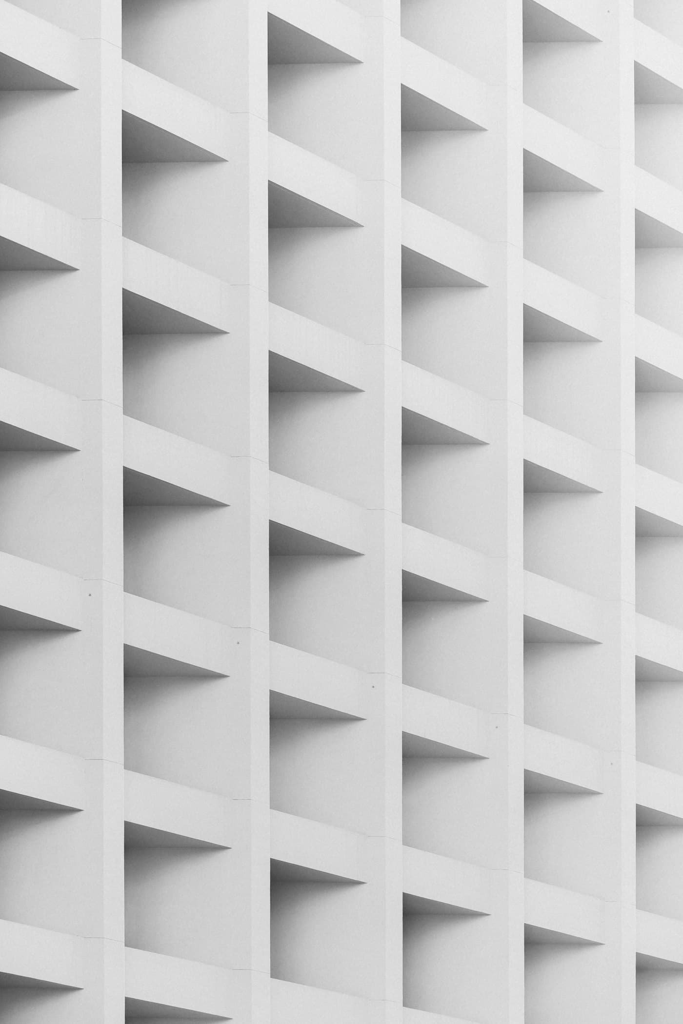 A white concrete facade of identical repeating window bays